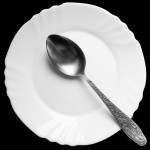 spoon on a white plate on a black background